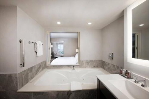 a bathroom with a tub and a sink and a bed at Niagara Falls Marriott Fallsview Hotel & Spa in Niagara Falls