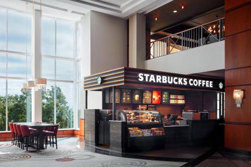 a starbucks coffee shop in a lobby with a table at Niagara Falls Marriott Fallsview Hotel & Spa in Niagara Falls