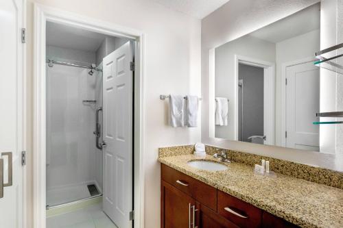 a bathroom with a sink and a shower and a mirror at Residence Inn Denver North/Westminster in Westminster
