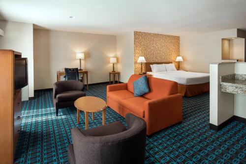 um quarto de hotel com uma cama, um sofá e cadeiras em Fairfield Inn Sacramento Cal Expo em Sacramento