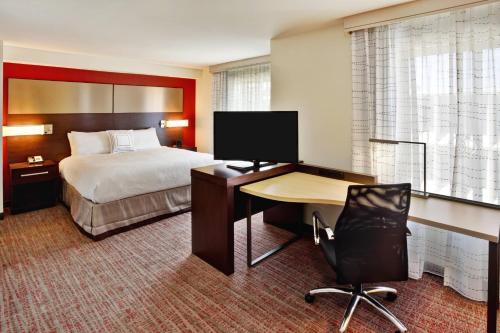 a hotel room with a bed and a desk with a computer at Residence Inn by Marriott Chicago Wilmette/Skokie in Wilmette
