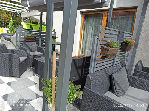 a row of chairs on a patio with plants at 3-Studio in Poznań