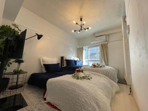 um quarto com 2 camas e um sofá em BEST LOCATED SHINJUKU CENTRAL Full-Furnished APARTMENT 3minWalk to Station2 em Tóquio