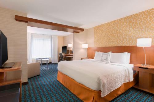 a hotel room with a bed and a flat screen tv at Fairfield Inn & Suites by Marriott Pittsburgh Airport/Robinson Township in Robinson Township