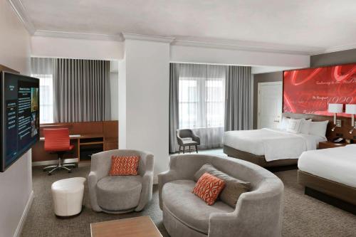 una camera con letto e una camera con letto e sedia di Courtyard St. Louis Downtown/Convention Center a Saint Louis