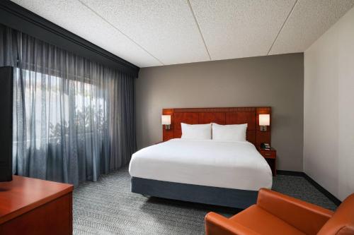 Habitación de hotel con cama y silla en Courtyard by Marriott San Antonio Medical Center, en San Antonio