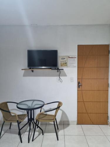 stół i krzesła z telewizorem na ścianie w obiekcie Portobello Hotel Orla w mieście Santarém