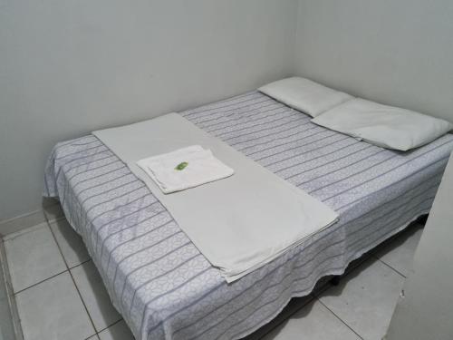 a bed with a white towel on top of it at Portobello Hotel Orla in Santarém