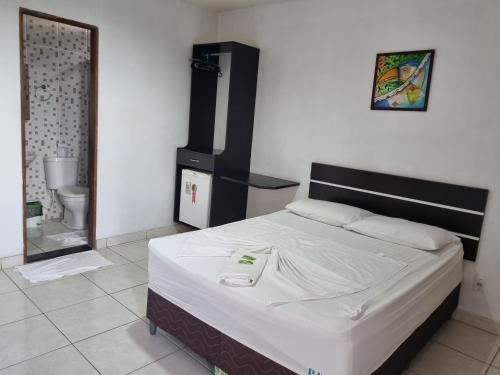 1 dormitorio con cama y baño con espejo. en Portobello Hotel Orla, en Santarém