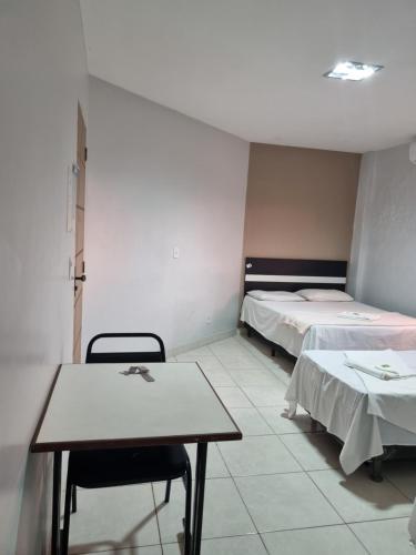 a room with two beds and a table and chairs at Portobello Hotel Orla in Santarém