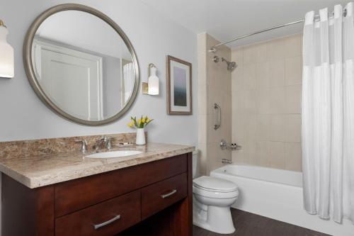 a bathroom with a sink and a toilet and a mirror at Marriott's Oceana Palms in Palm Beach Shores