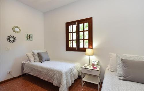 een witte kamer met een bed en een raam bij Lovely Home In Cercado De Espino With Swimming Pool in Los Palmitos