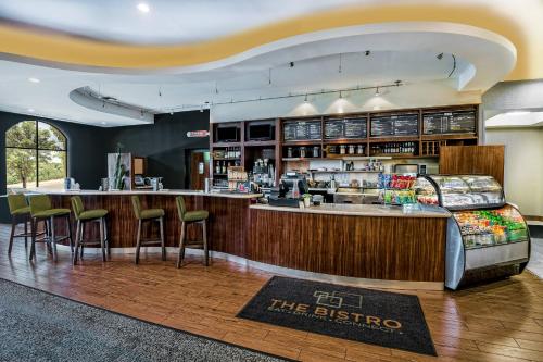 a restaurant with a bar and stools in a room at Courtyard by Marriott San Antonio SeaWorld®/Westover Hills in San Antonio