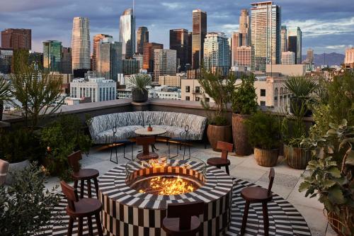 a patio with a fire pit with a view of a city at Downtown Los Angeles Proper Hotel, a Member of Design Hotels in Los Angeles