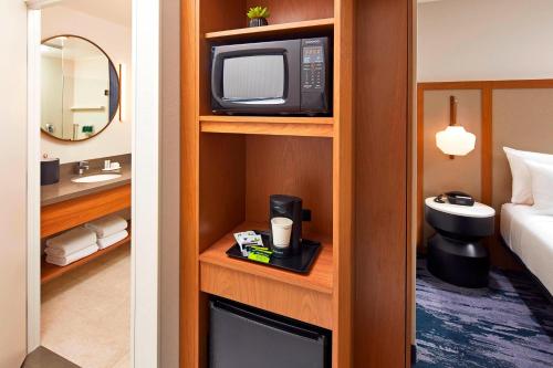 a hotel room with a television and a bathroom at Fairfield by Marriott Inn & Suites Indio Coachella Valley in Indio
