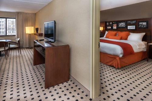 a hotel room with a bed and a flat screen tv at Delta Hotels by Marriott Utica in Utica