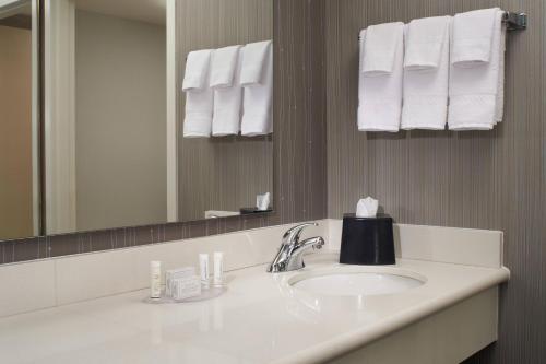 a bathroom with a sink and a mirror and towels at Courtyard Toledo Maumee/Arrowhead in Maumee