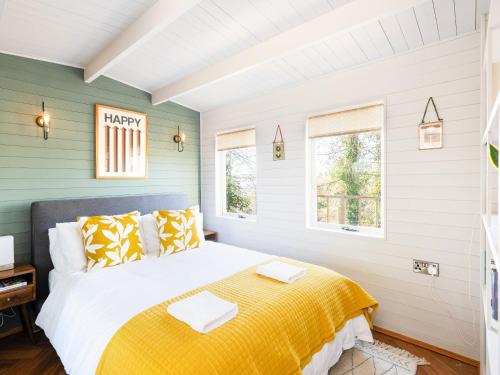 a bedroom with a bed and two windows at The Cosy Cabin in Clapton in Gordano