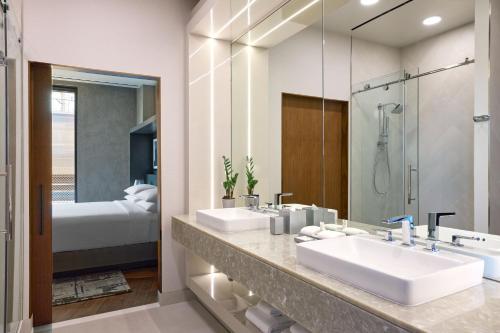 a bathroom with two sinks and a mirror and a bed at Washington Marriott Capitol Hill in Washington, D.C.