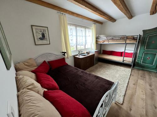 1 dormitorio con 1 cama con almohadas rojas en Idyllischer Bauernhof mit Charme en Benken