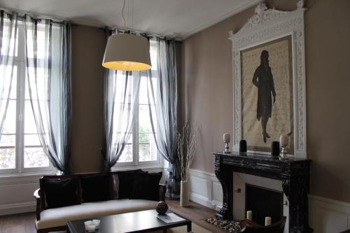a living room with a fireplace and a picture on the wall at Maison Charles Maurice in Chalais