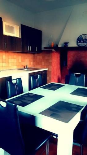 a kitchen with a white table and chairs and a counter at Casa Neva in Cannobio