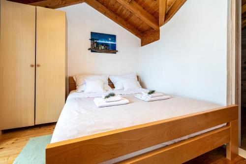 a bedroom with a large bed with white sheets at Secluded fisherman's cottage Cove Soline, Pasman - 8222 in Kraj