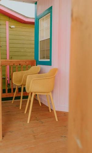 two chairs sitting on the porch of a house at Agave Tiny House at Cactus Flower-HOT TUB-Pet Friendly-No Pet Fees! in Albuquerque
