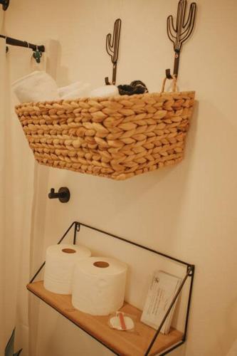 a basket hanging on a wall with toilet paper at Agave Tiny House at Cactus Flower-HOT TUB-Pet Friendly-No Pet Fees! in Albuquerque