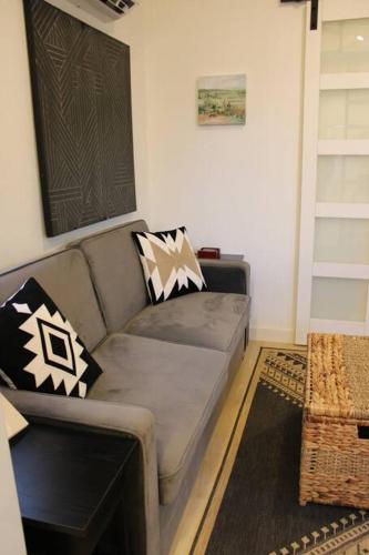 a living room with a couch with pillows on it at Agave Tiny House at Cactus Flower-HOT TUB-Pet Friendly-No Pet Fees! in Albuquerque