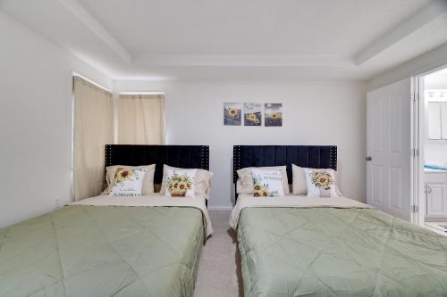 2 camas en una habitación con paredes blancas en Villa Macondo at Mt. Poconos with game room and Fire Pit, en Tobyhanna