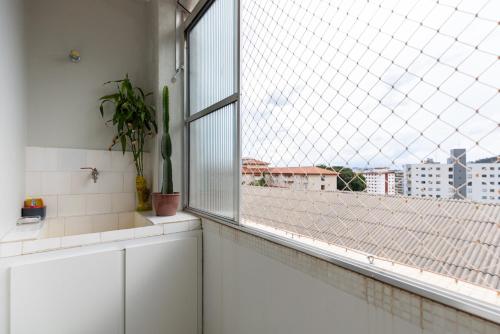 a bathroom with a window with a view of a city at Apart Budapest - Conforto na melhor Rua de Águas de Lindóia in Águas de Lindóia