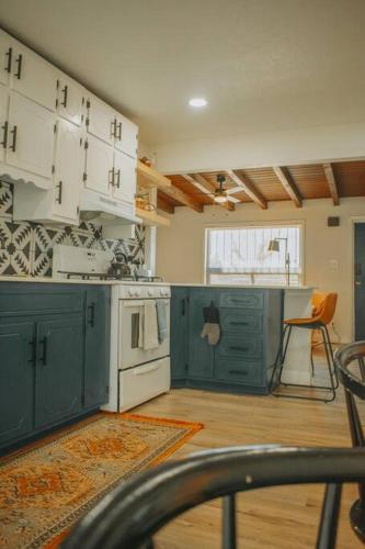 a kitchen with green cabinets and a white stove top oven at Casa Charleston-3BR-2Bath-Private HOT TUB-Pet Friendly-No Pet Fees! in Albuquerque