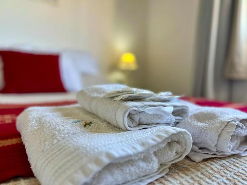 een stapel handdoeken bovenop een bed bij Palotes Sierras Cabañas in Villa Giardino
