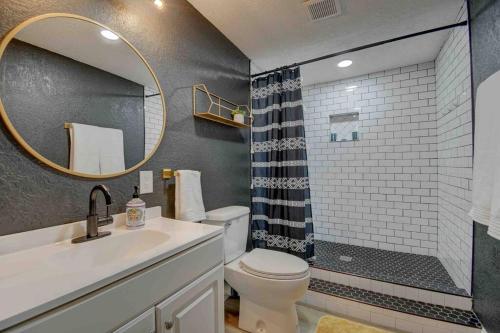 a bathroom with a sink and a toilet and a mirror at Casa Charleston-3BR-2Bath-HOT TUB-Pet Friendly-No Pet Fees! in Albuquerque