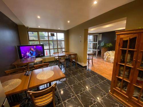 a living room with tables and chairs and a flat screen tv at AH Rent in Quintero