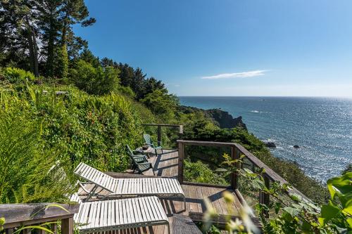 a staircase with chairs and a view of the ocean at Turtle Rocks Oceanfront Inn in Trinidad