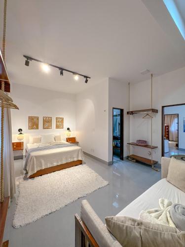 una camera da letto bianca con due letti e un divano di Casa do Sino - Casa de família nos Lençóis Maranhenses! a Barreirinhas