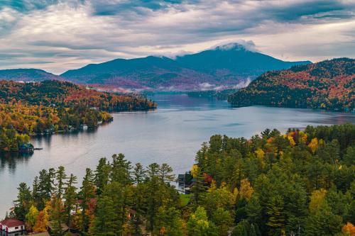 vistas a un lago con árboles y montañas en The Pines Inn, en Lake Placid