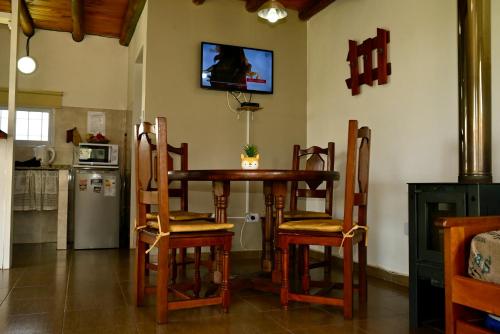 ビージャ・ヒアルディノにあるPalotes Sierras Apartのキッチン(テーブル、椅子、壁掛けテレビ付)