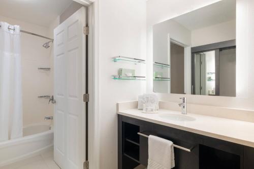 a bathroom with a sink and a shower and a mirror at Residence Inn by Marriott Williamsburg in Williamsburg