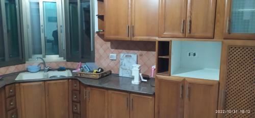 a kitchen with wooden cabinets and a sink at The Room of Cultures in Ramallah
