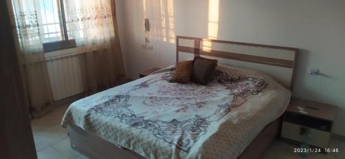 um quarto com uma cama com um cobertor e uma janela em The Room of Cultures em Ramallah