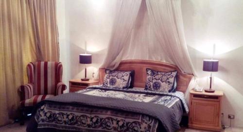 1 dormitorio con 1 cama con 2 lámparas y 1 silla en Hotel Real Santander, en Puebla