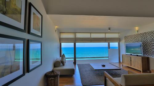 a living room with a view of the ocean at Pandanus Beach Resort & Spa in Bentota