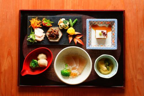 a tray with bowls of food on a table at Ryoan Fukinotou in Bungotakada