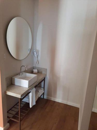 a bathroom with a sink and a mirror at Hot Beach Suites Olimpia Resort in Olímpia