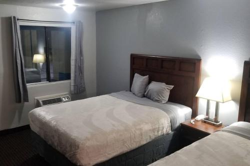 een hotelkamer met 2 bedden en een raam bij OSU 2 Queen Beds Hotel Room 136 Wi-Fi Hot Tub Booking in Stillwater