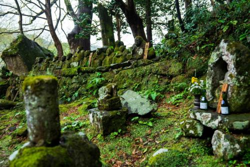 an old grave yard with rocks and trees at Ryoan Fukinotou in Bungotakada