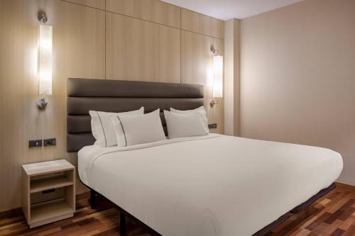 uma grande cama branca num quarto de hotel em AC Hotel Tarragona by Marriott em Tarragona